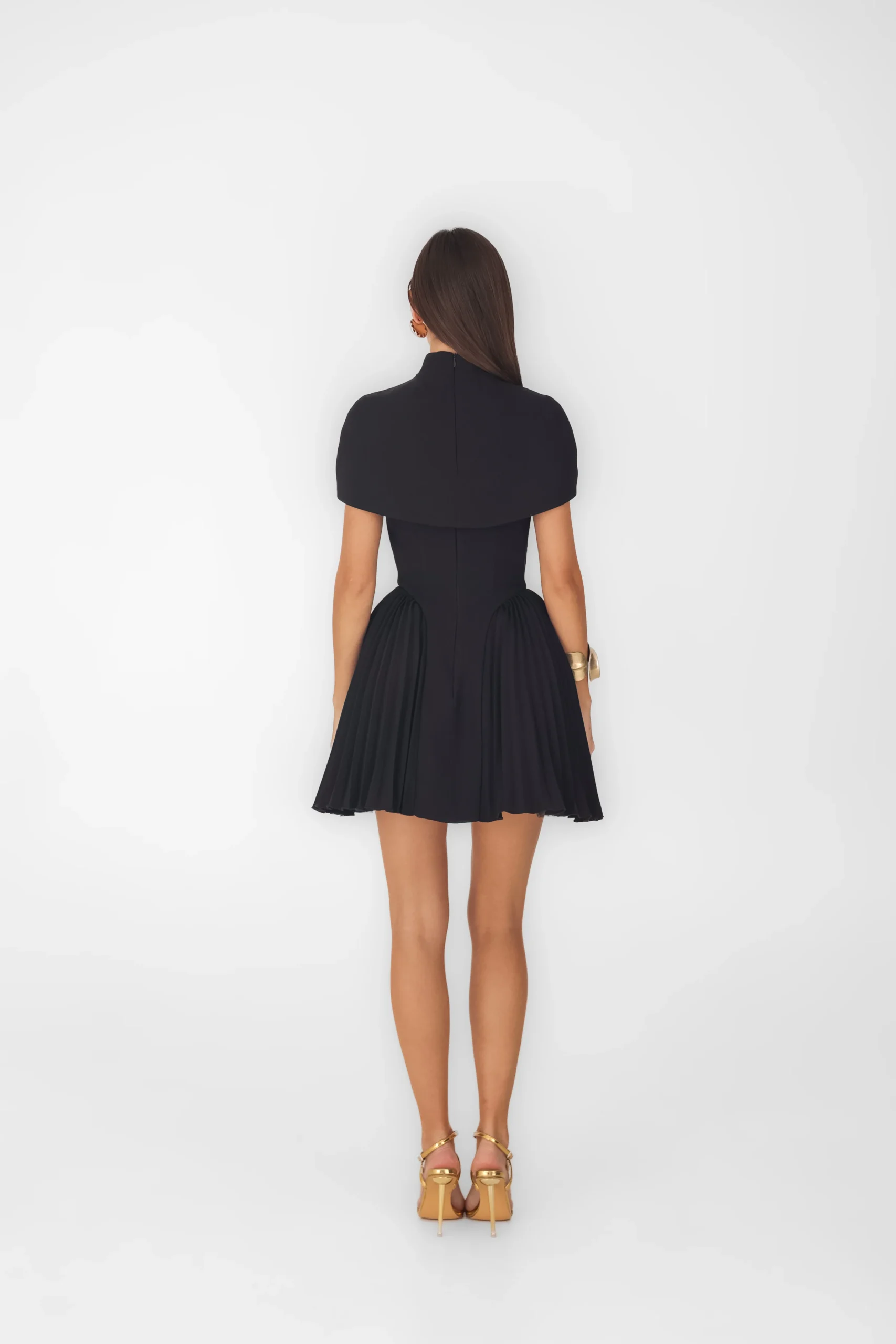 Back view of the short cape worn with a flared black skirt