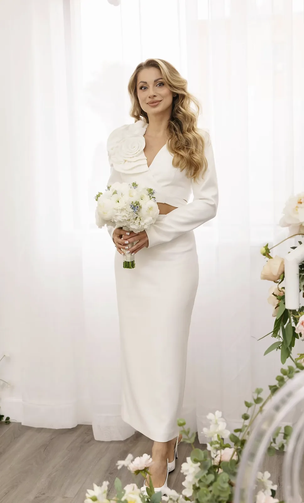 Stylish white bridal suit with the Candy pencil skirt and the cropped Rosalie jacket with a 3D flower by REPULO'S, full-length view