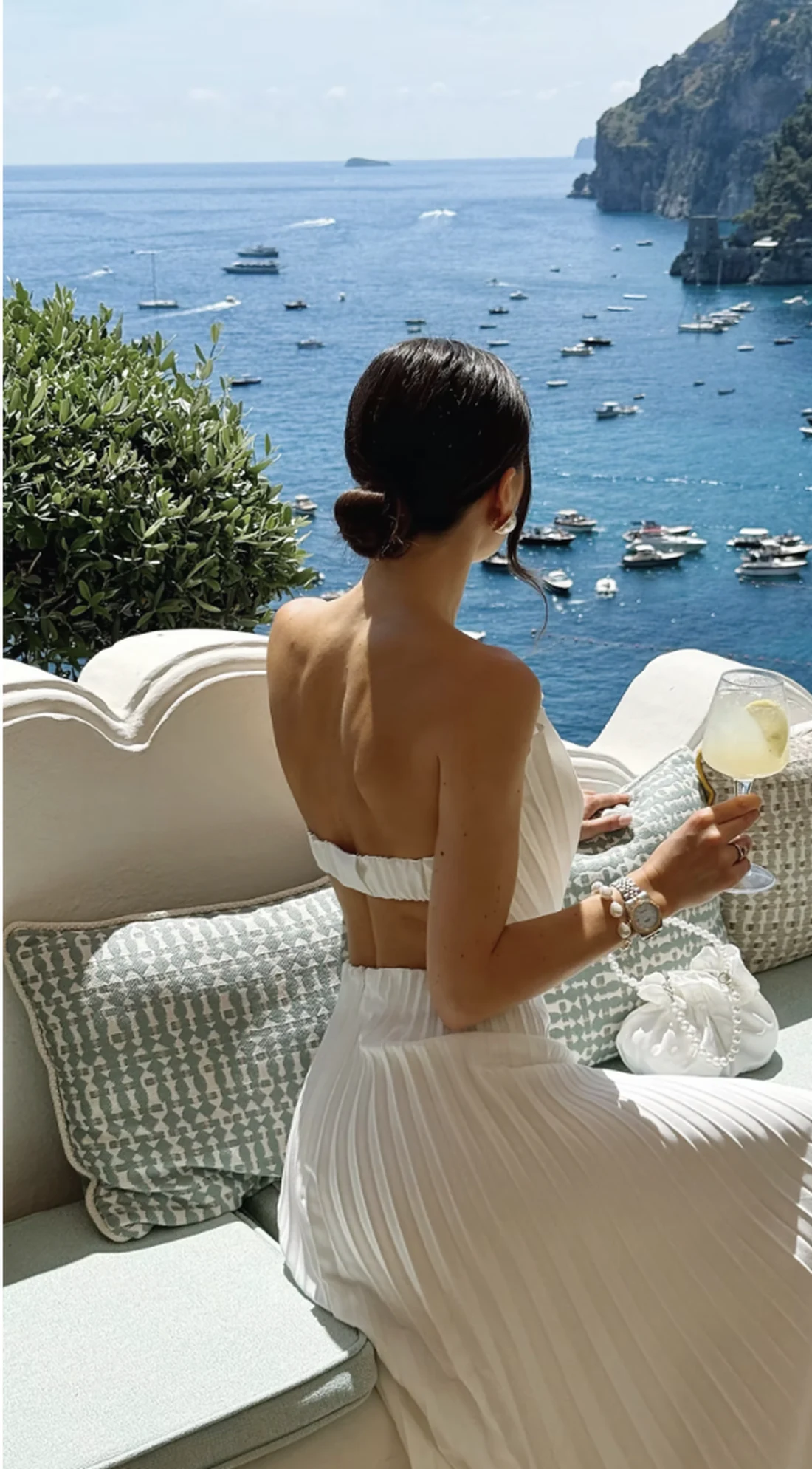 Plisowana sukienka maxi Shell od REPULO'S na tarasie w Positano z widokiem na zatoke