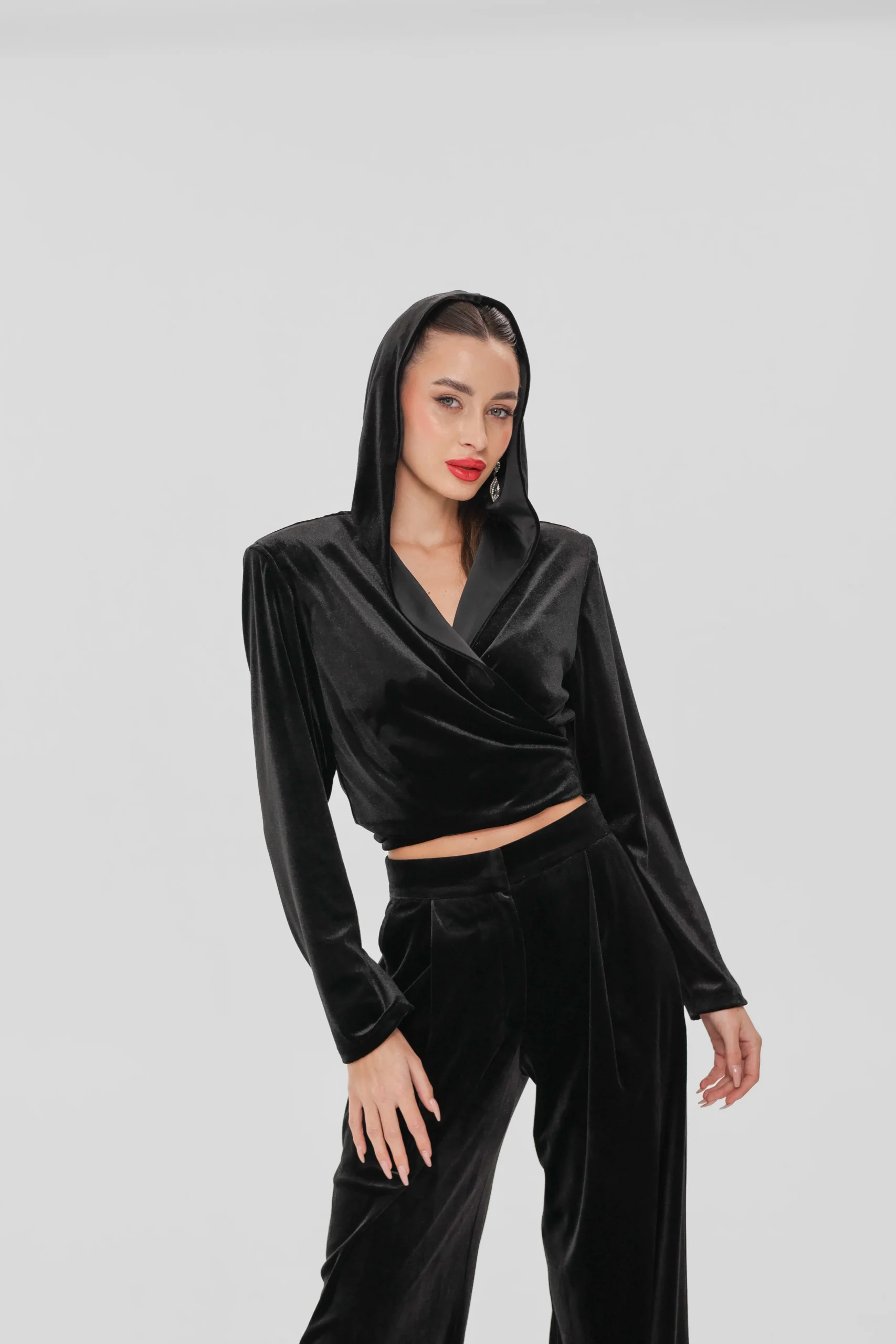 Velvet wrap top with hood worn with matching wide leg velvet trousers, front view