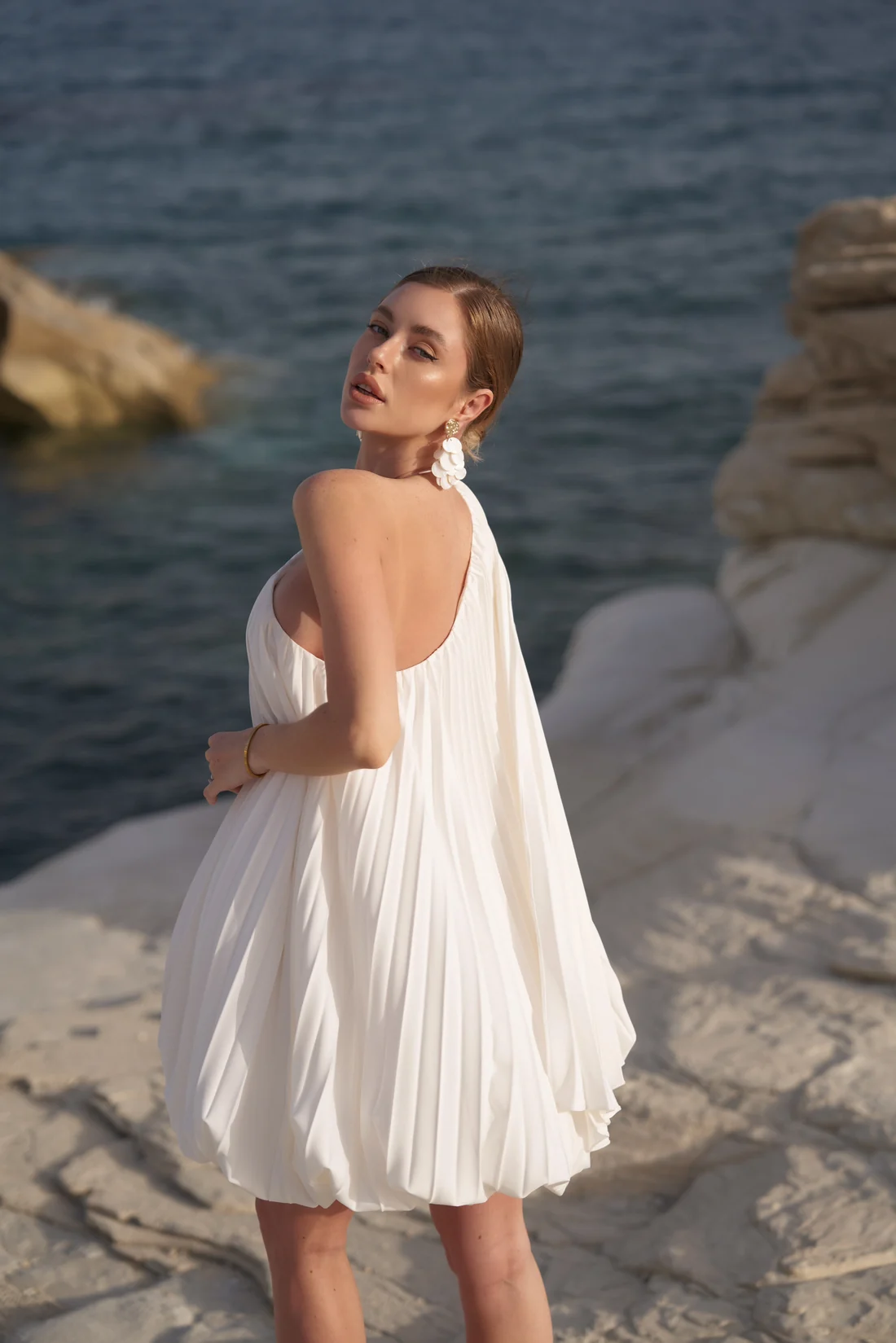 REPULO'S model in the white Bon Bon one-shoulder pleated dress with a full bubble hem