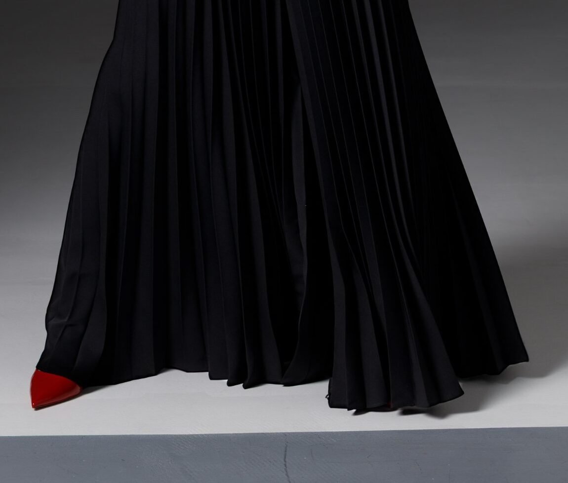 Pleats of REPULO'S Amber palazzo trousers in motion with red high heels