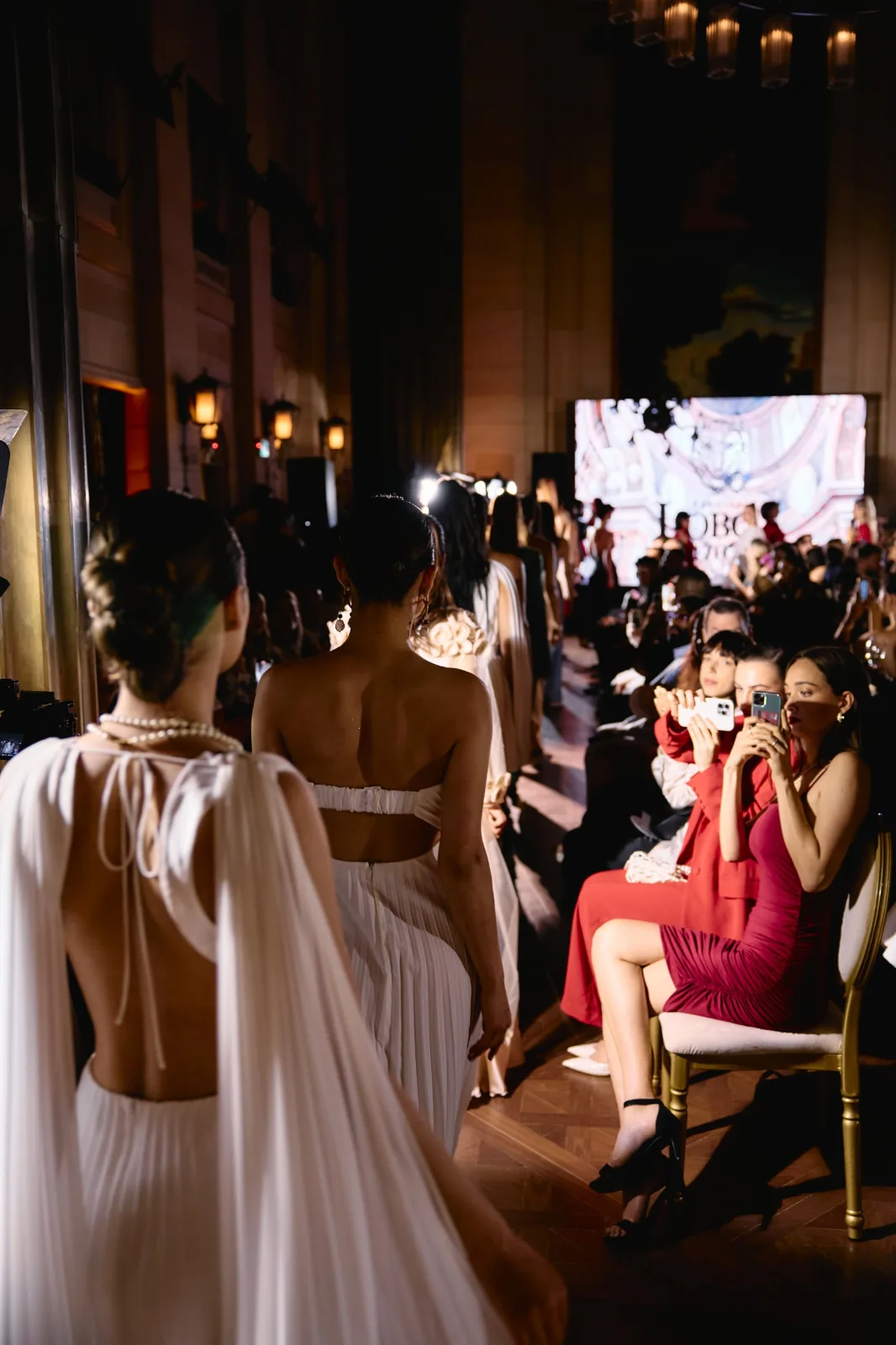 Modelos con vestidos plisados blancos de REPULO'S en el desfile de la marca