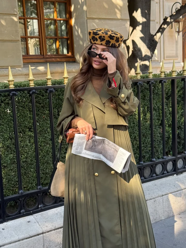 Khaki Amber maxi trench coat with a beige suede bag and a newspaper