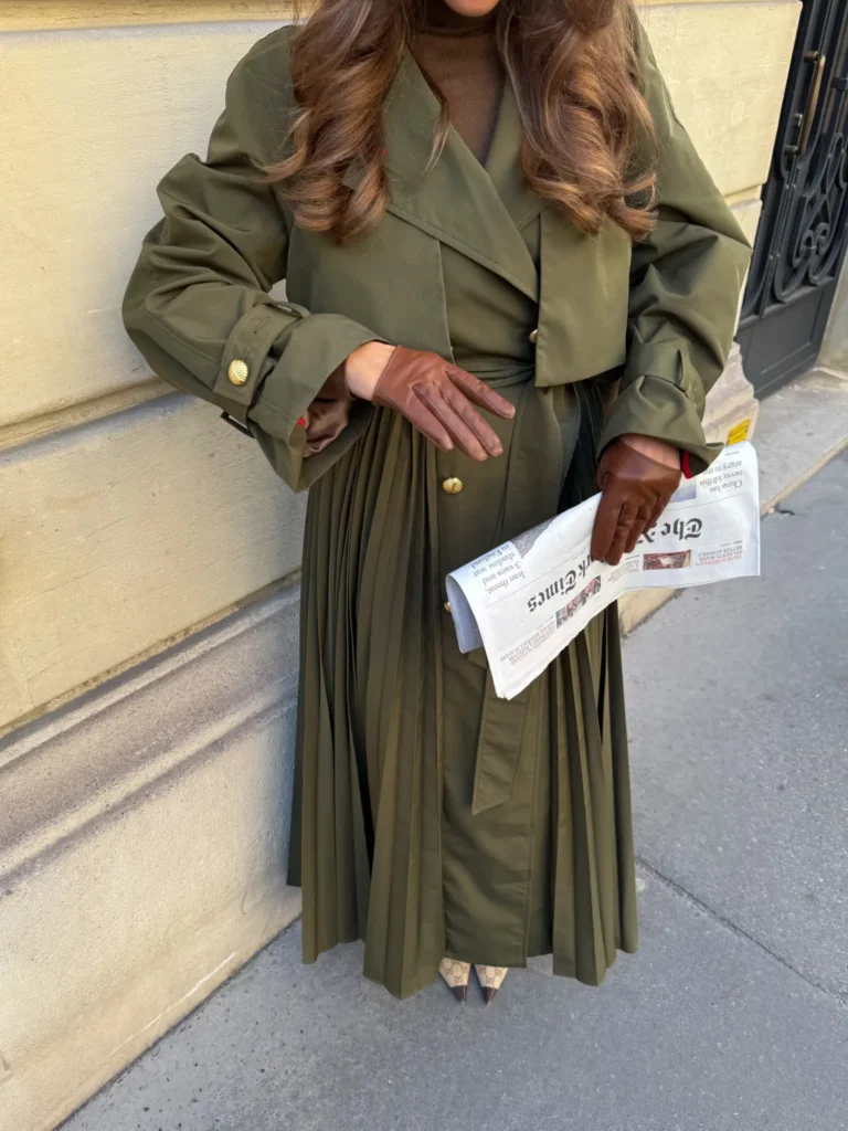 Gold shell-shaped buttons and brown leather gloves on a khaki trench coat