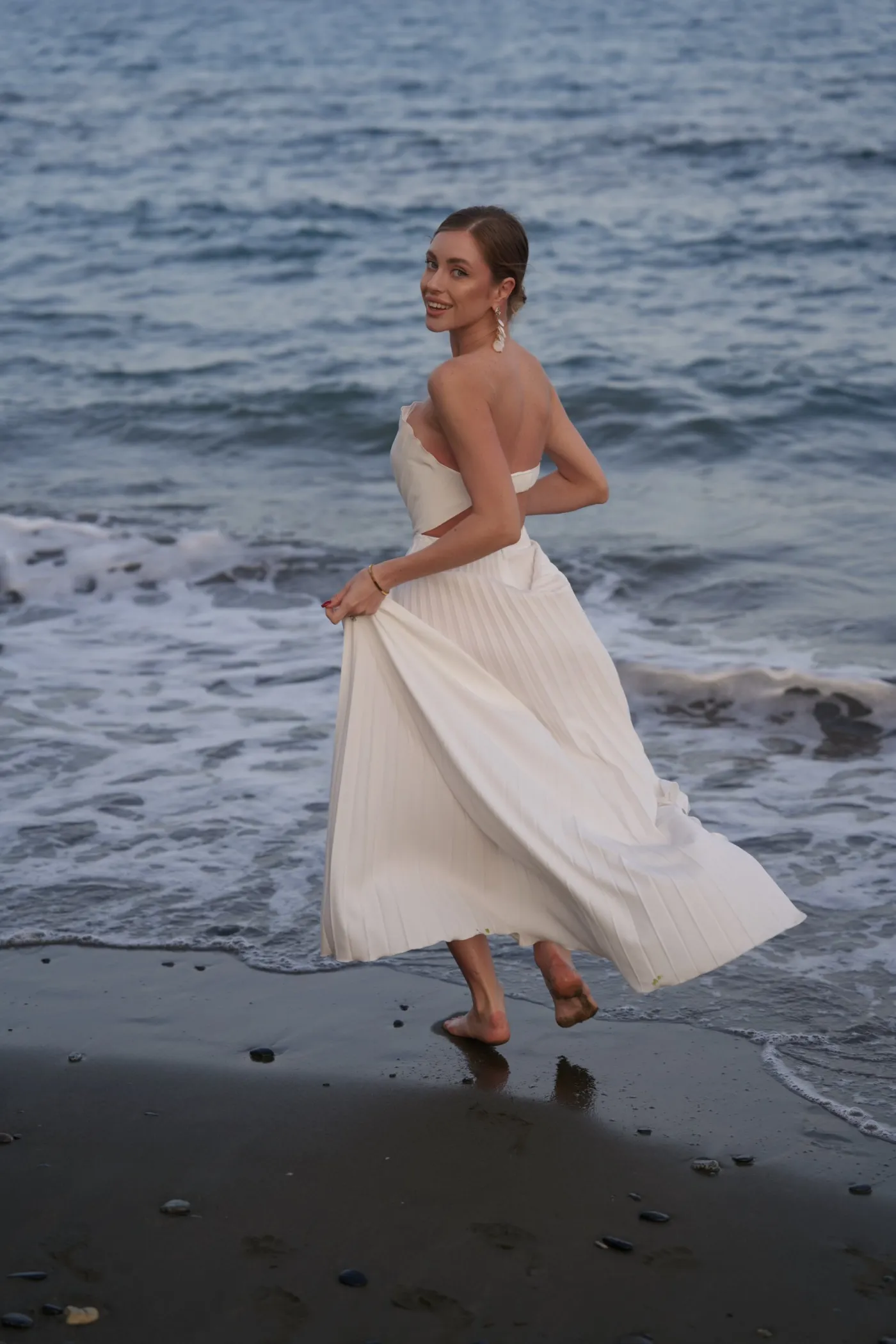 Robe longue plissée blanche Shell de REPULO'S à dos nu au bord de la mer